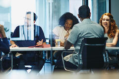 team sitting in a boardroom working and talking